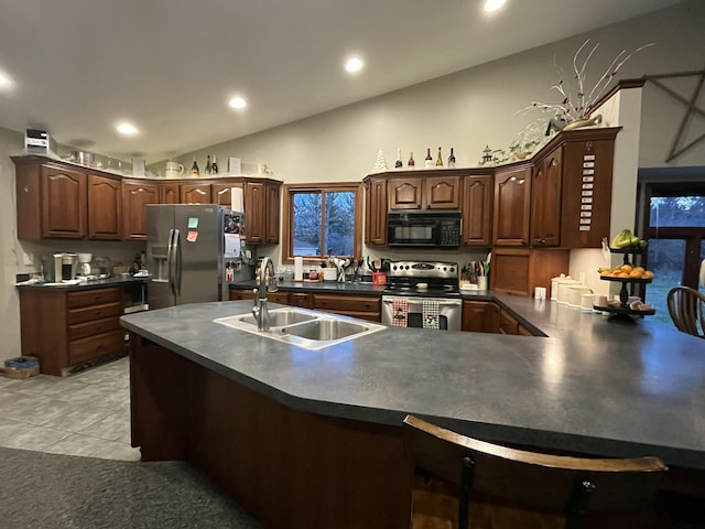 9610 Grange Ave NE, Rockford, MI 49341 - kitchen featuring dark countertops, appliances with stainless steel finishes, a sink, a peninsula, and recessed lighting