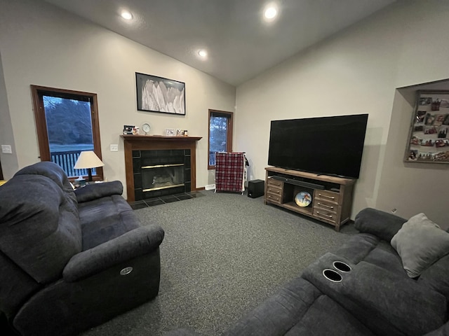 9610 Grange Ave NE, Rockford, MI 49341 - living room with a tiled fireplace, dark colored carpet, vaulted ceiling, and recessed lighting
