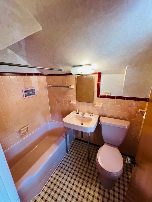 9327 Cloverlawn St, Detroit, MI 48204 - bathroom featuring a textured ceiling, toilet, a sink, tile walls, and a textured wall