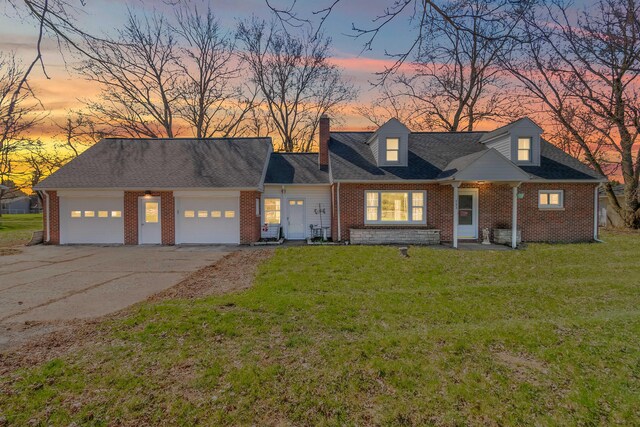 view of front of house featuring a lawn, an attached garage, brick siding, and concrete driveway