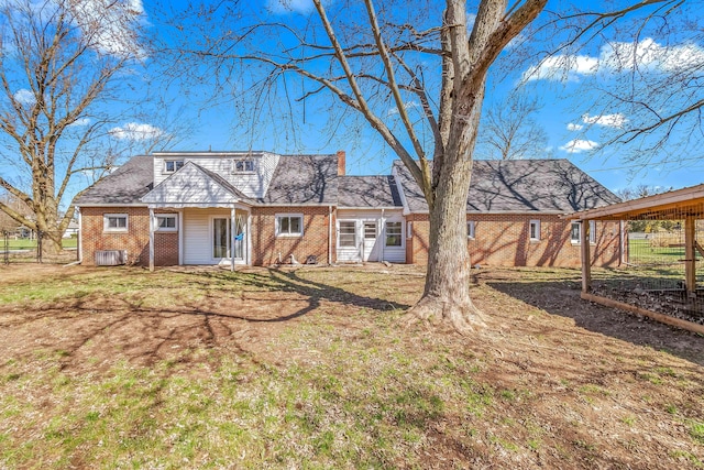 back of property with brick siding and a yard