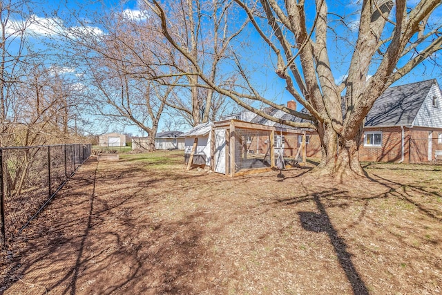 view of yard featuring an outdoor structure, exterior structure, and fence