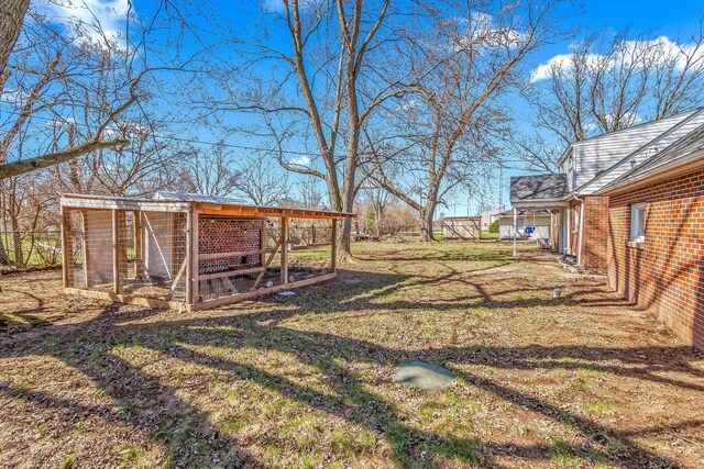 view of yard with exterior structure, an outbuilding, and fence