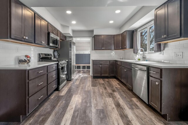 kitchen featuring dark wood-style flooring, light countertops, appliances with stainless steel finishes, dark brown cabinetry, and a sink