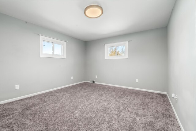 carpeted empty room with baseboards, visible vents, and a healthy amount of sunlight