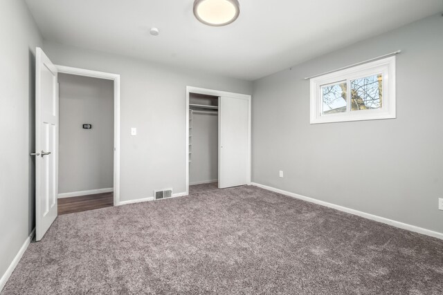 unfurnished bedroom with carpet, a closet, and baseboards