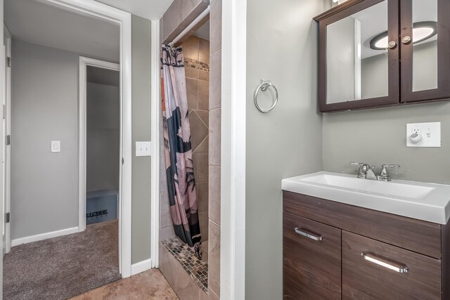 bathroom featuring vanity, baseboards, and a shower stall