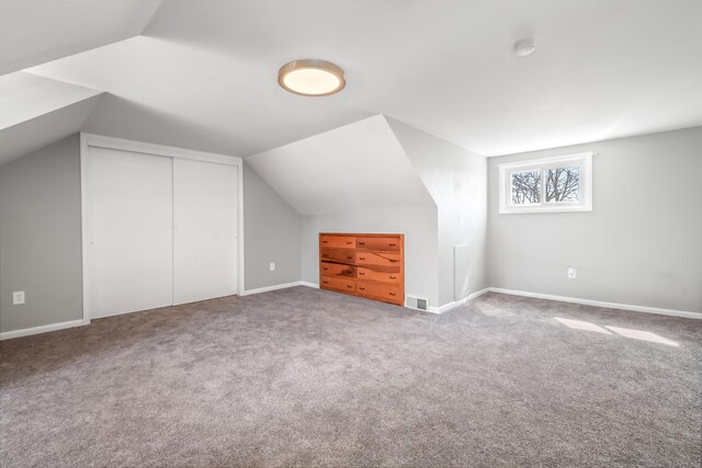bonus room with carpet floors, visible vents, and lofted ceiling