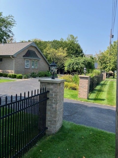 view of gate with a lawn and fence