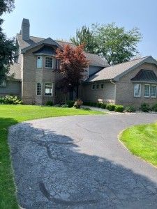 view of front facade featuring a chimney, curved driveway, and a front yard