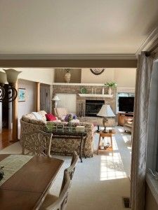 living room with a fireplace and crown molding