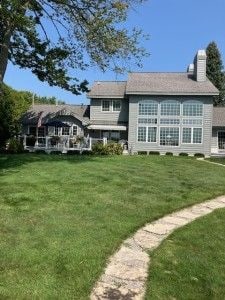 rear view of property featuring a chimney and a yard