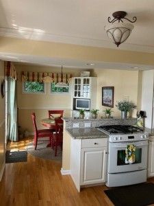 kitchen featuring crown molding, white range with gas cooktop, light wood finished floors, and white cabinetry