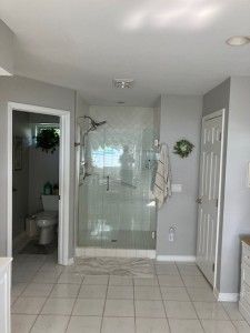 bathroom with vanity, a shower stall, tile patterned flooring, and baseboards