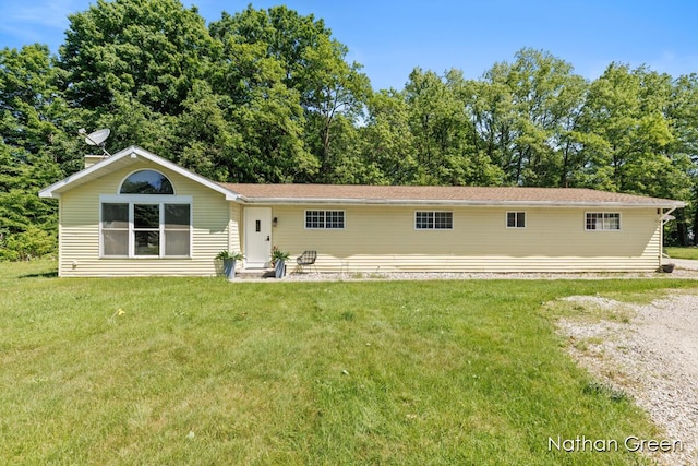rear view of house featuring a lawn
