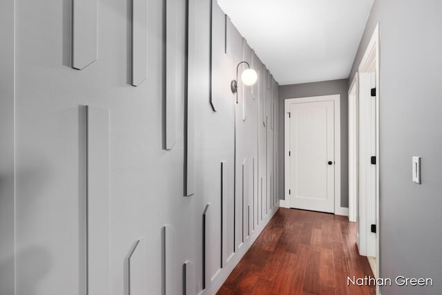 hallway featuring baseboards and dark wood-style flooring