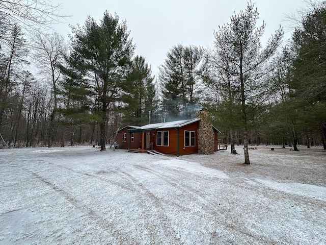 view of snow covered exterior featuring a chimney