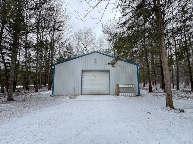 snow covered garage featuring a detached garage