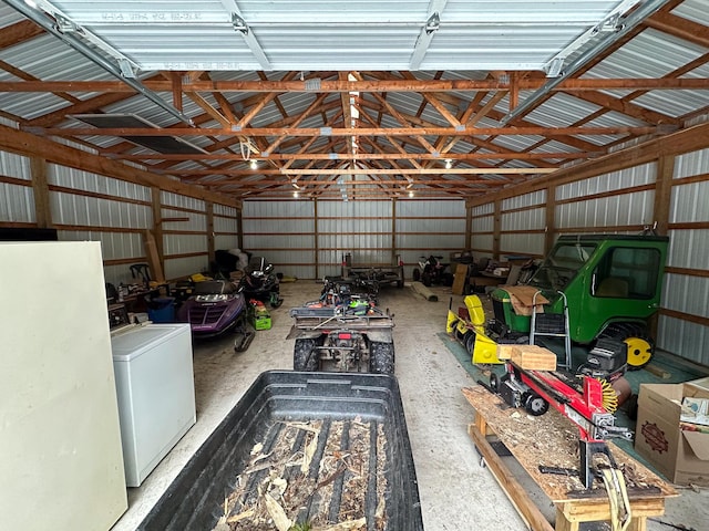 garage with freestanding refrigerator, washer / dryer, and metal wall