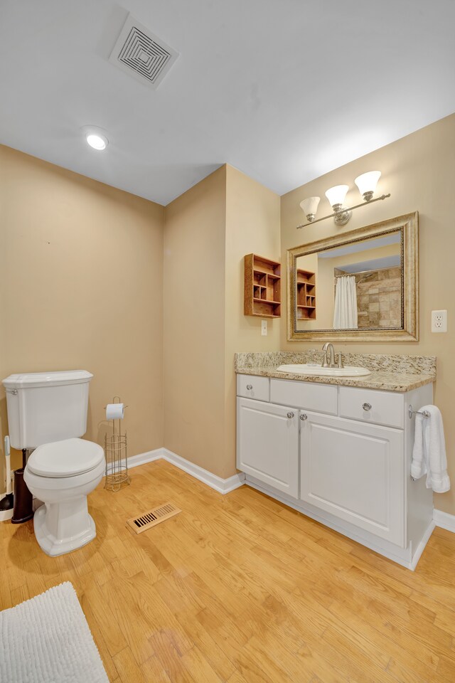 4423 Groveland Ave, Royal Oak, MI 48073 - full bathroom with visible vents, toilet, wood finished floors, and baseboards