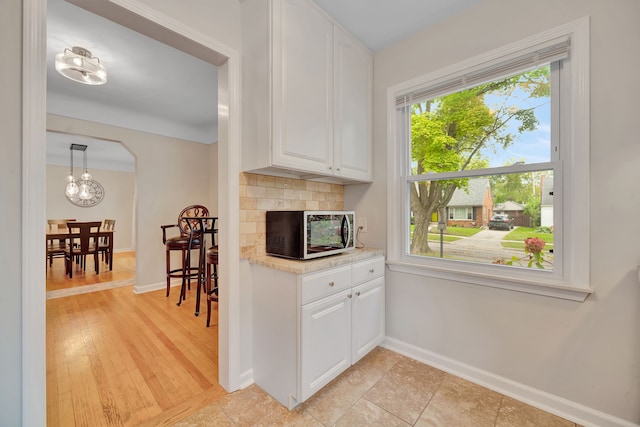 4423 Groveland Ave, Royal Oak, MI 48073 - kitchen with white cabinetry, stainless steel microwave, light countertops, and backsplash