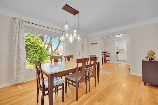 4423 Groveland Ave, Royal Oak, MI 48073 - dining area featuring arched walkways, light wood-style floors, and baseboards