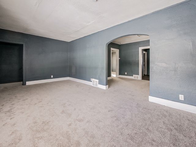 14011 Roselawn St, Detroit, MI 48238 - carpeted spare room featuring arched walkways, visible vents, and baseboards