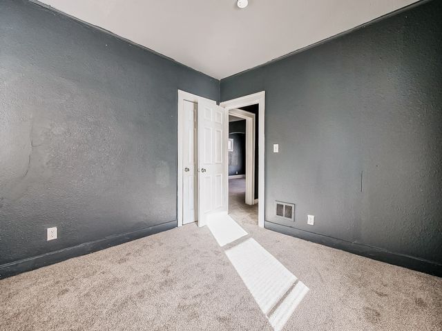 14011 Roselawn St, Detroit, MI 48238 - empty room featuring a textured wall, carpet, and visible vents