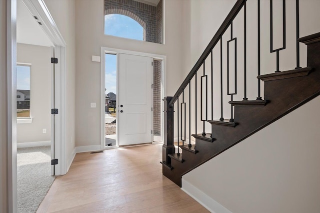 24599 Brookshire Dr, Macomb, MI 48042 - entryway with a high ceiling, light wood finished floors, baseboards, and stairway