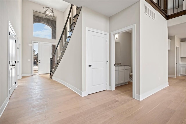 24599 Brookshire Dr, Macomb, MI 48042 - foyer featuring visible vents, light wood-type flooring, stairway, baseboards, and a high ceiling