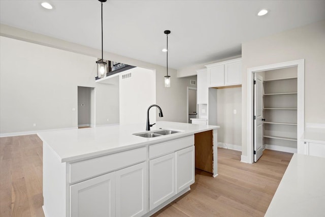 24599 Brookshire Dr, Macomb, MI 48042 - kitchen with visible vents, a sink, white cabinetry, and light wood-type flooring
