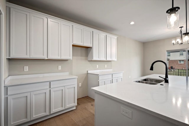 24599 Brookshire Dr, Macomb, MI 48042 - kitchen with a sink, white cabinetry, recessed lighting, light wood-type flooring, and pendant lighting
