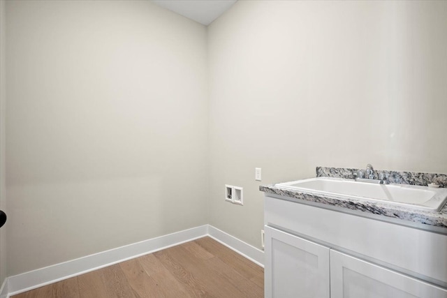 24599 Brookshire Dr, Macomb, MI 48042 - laundry room featuring cabinet space, a sink, hookup for a washing machine, baseboards, and light wood-type flooring