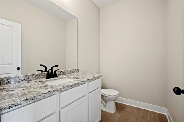 24599 Brookshire Dr, Macomb, MI 48042 - half bathroom featuring baseboards, vanity, toilet, and wood finished floors