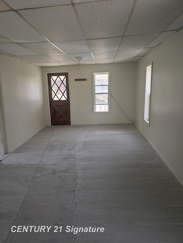 unfurnished room with a wealth of natural light, light carpet, and a paneled ceiling