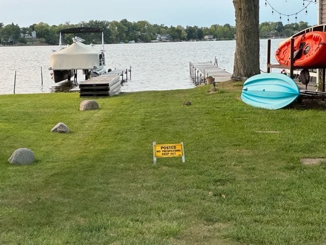 exterior space featuring a lawn, a water view, and boat lift