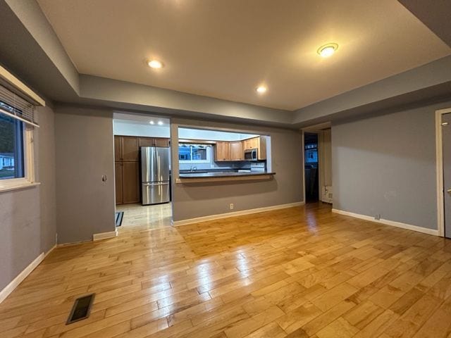 unfurnished living room featuring baseboards, recessed lighting, visible vents, and light wood-style floors