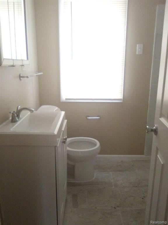 14595 Terry St, Detroit, MI 48227 - half bathroom featuring tile patterned floors, toilet, baseboards, and vanity