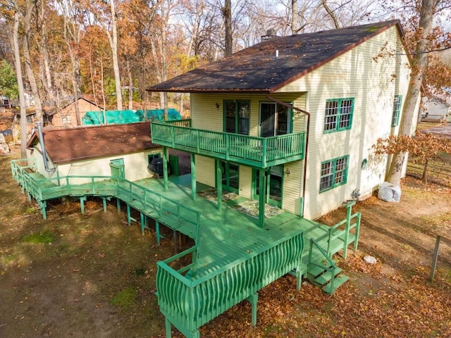 4725 Hickory Dr, Highland, MI 48356 - back of property featuring a wooden deck and roof with shingles