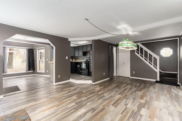 4725 Hickory Dr, Highland, MI 48356 - unfurnished living room with wood finished floors and stairs