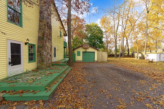 4725 Hickory Dr, Highland, MI 48356 - view of home's exterior with asphalt driveway, a detached garage, and a shed
