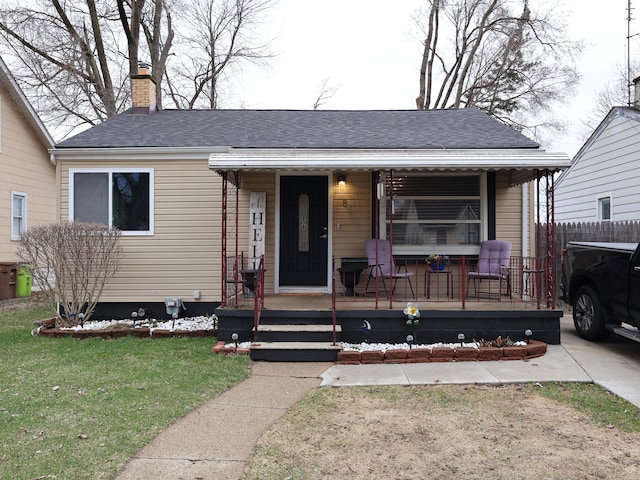 81 E Fairmount Ave, Pontiac, MI 48340 - view of front of home with covered porch, roof with shingles, fence, a front lawn, and a chimney