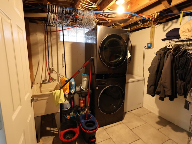 81 E Fairmount Ave, Pontiac, MI 48340 - laundry room featuring tile patterned floors, stacked washing maching and dryer, laundry area, a sink, and concrete block wall