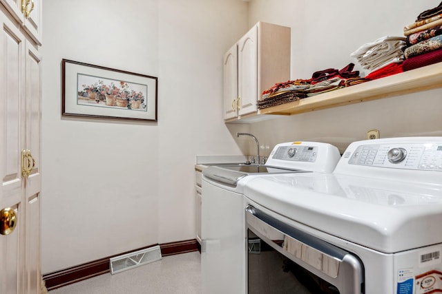 6242 131st St, Saugatuck, MI 49453 - clothes washing area featuring washer and clothes dryer, baseboards, a sink, visible vents, and cabinet space