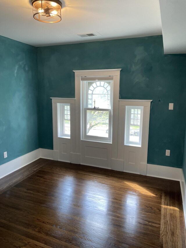 entryway with dark wood finished floors, baseboards, and visible vents