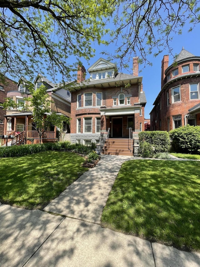 traditional style home featuring covered porch, brick siding, a front lawn, and a chimney