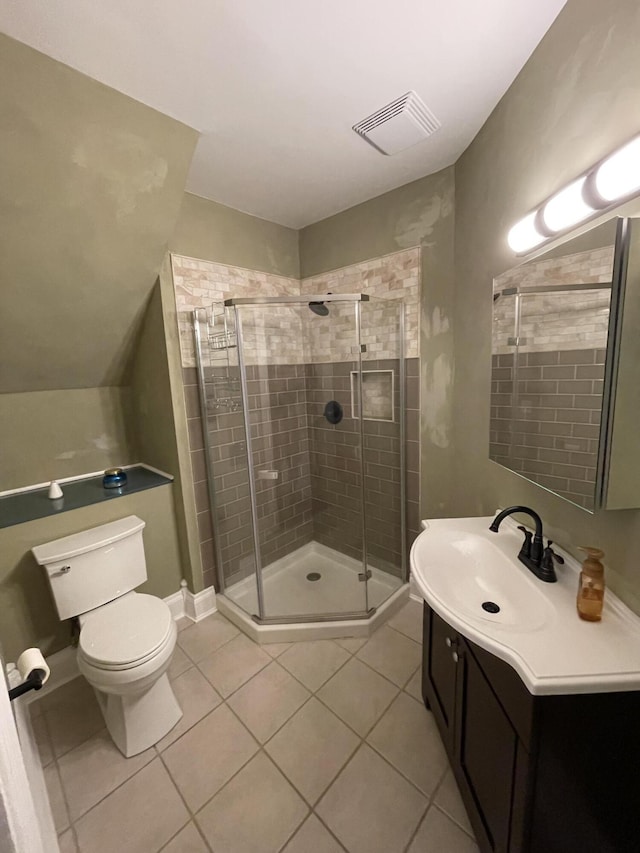 bathroom featuring toilet, vanity, a shower stall, tile patterned flooring, and visible vents