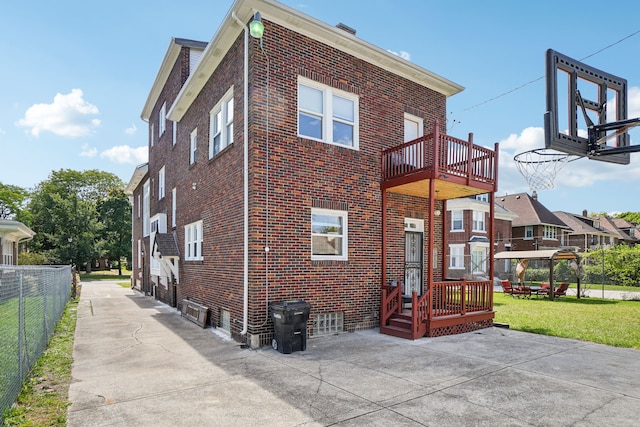 rear view of property with brick siding and a balcony