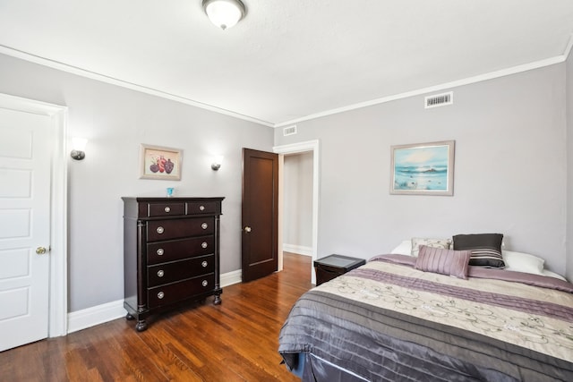 bedroom featuring dark wood-type flooring, crown molding, and baseboards