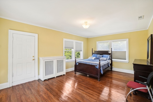 bedroom featuring wood finished floors, baseboards, and crown molding